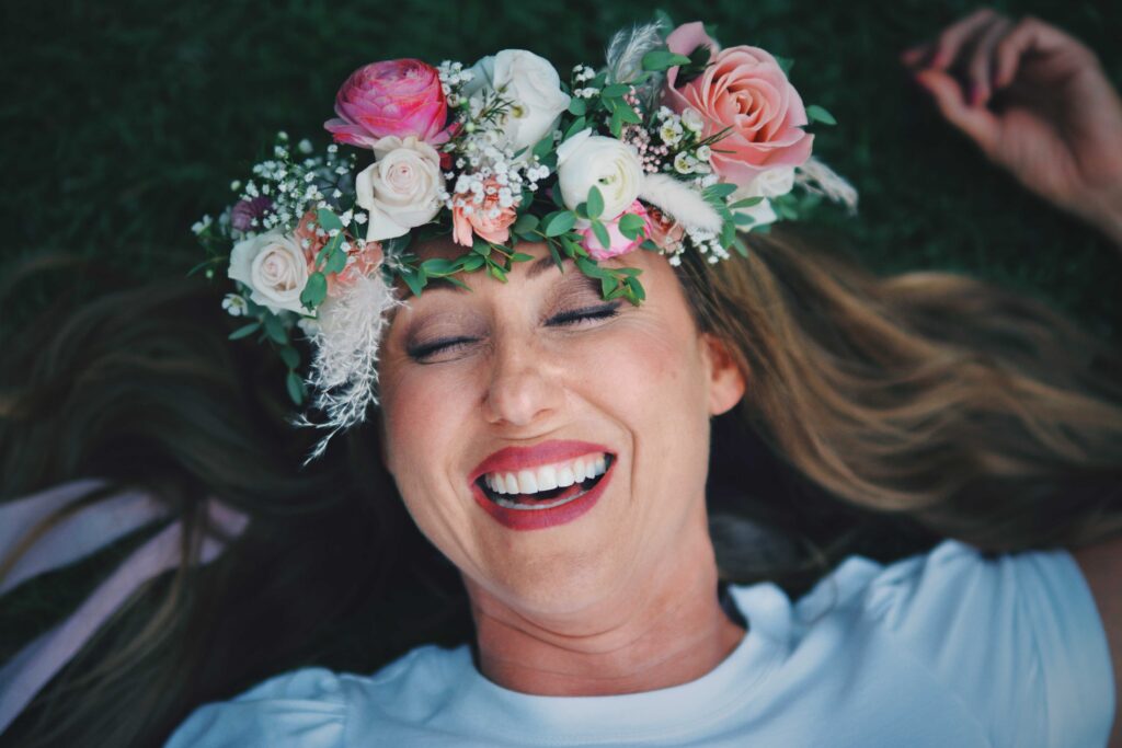 Sonia laughs on the ground in her flower crown.