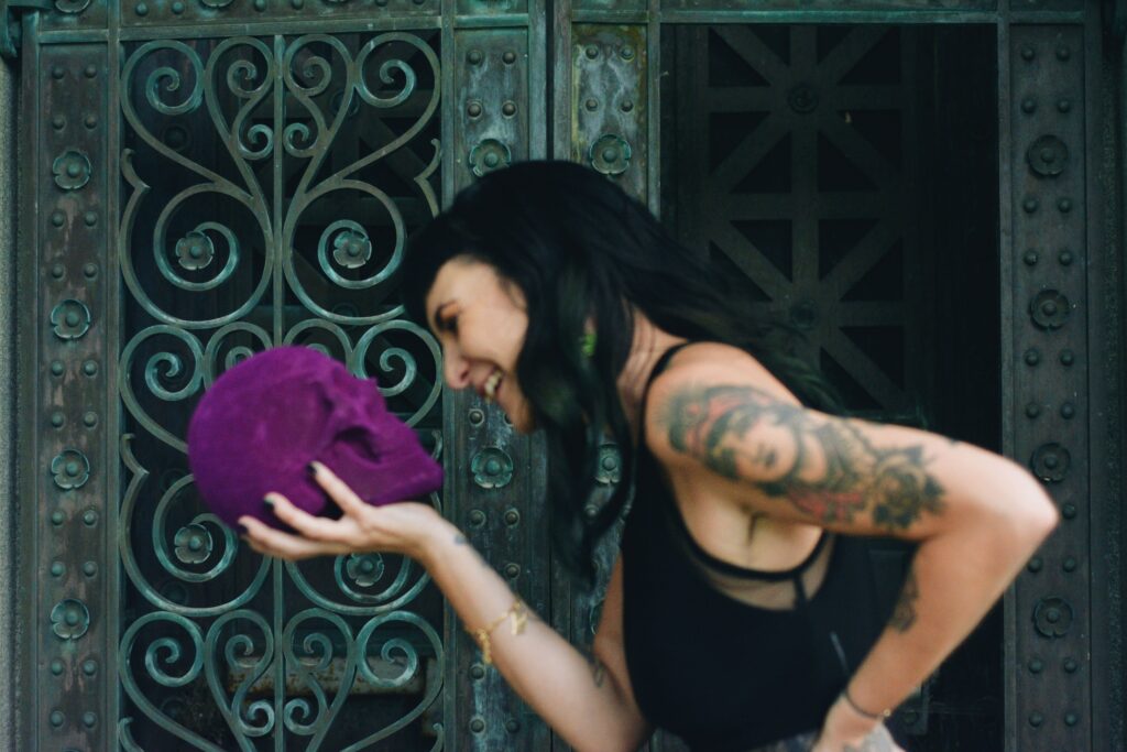 Rene laughs along with the purple skull she's holding.
