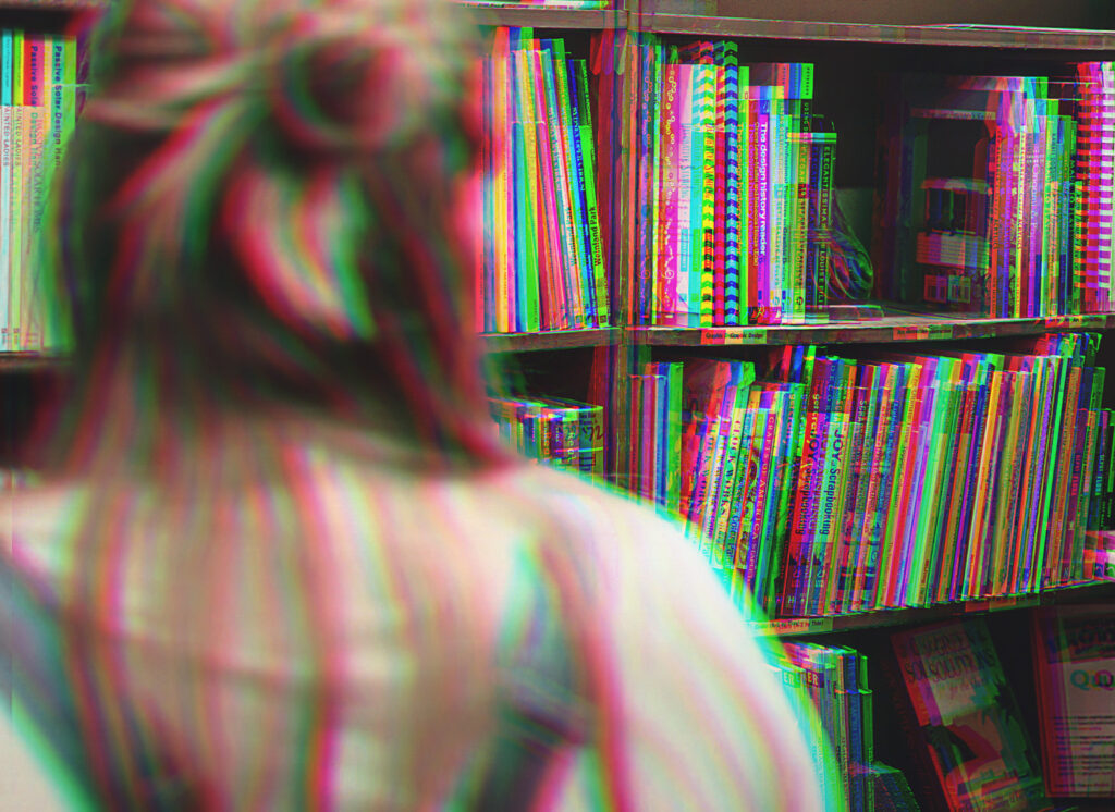 We see the back of Brianne's head while she surveys the bookshelf. Everything is shifted in color to look like a 3D red and blue photo.